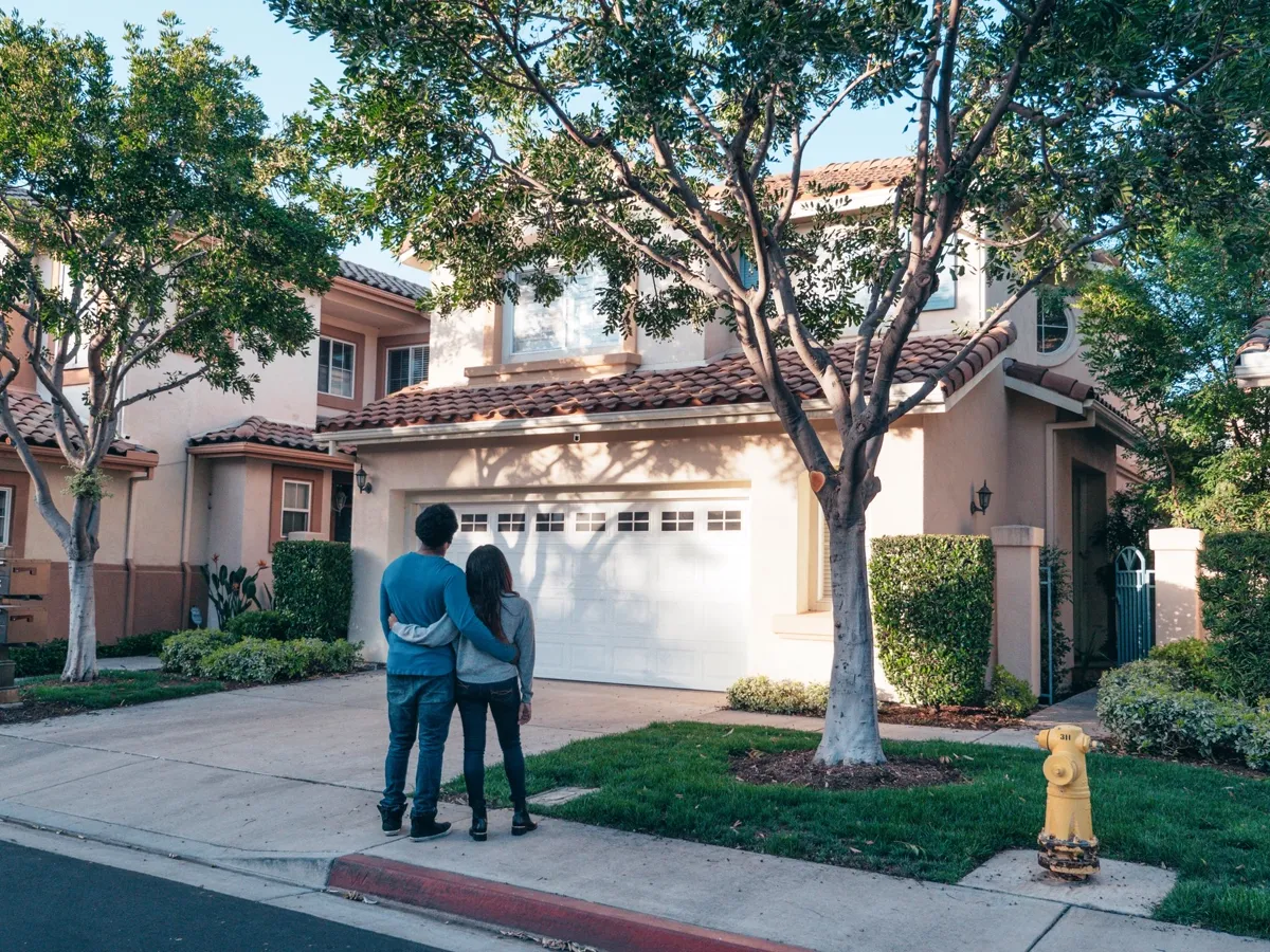 Homeowners standing in front of their protected home
